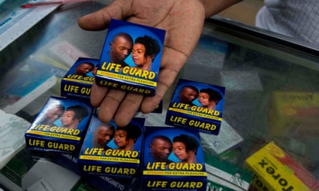 A pharmacist displays a pack of Life Guard condoms at a store in the Ugandan capital Kampala