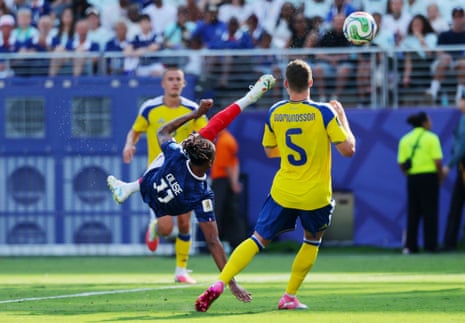France's Michael Olise shoots acrobatically.