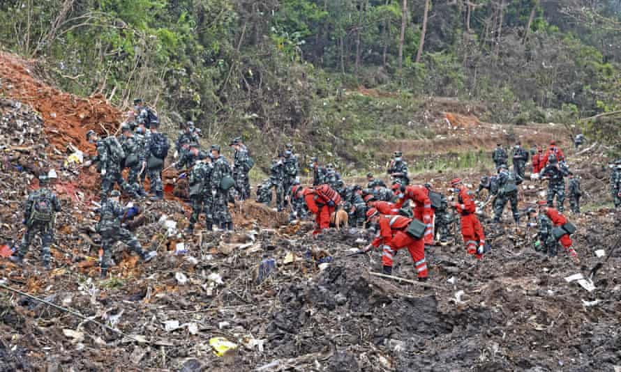 Rescue workers search for the black boxes at a plane crash site in Tengxian county.