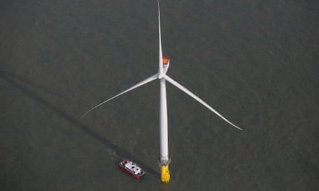A boat passes a wind turbine in the North Sea at the London Array offshore wind farm