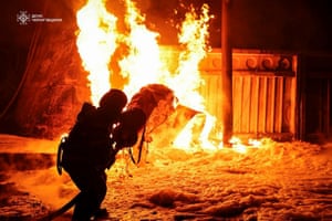 A firefighter silhouetted by flames