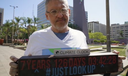 Adam McKay tenant une horloge climatique lors d'une manifestation contre le changement climatique à Los Angeles l'année dernière.
