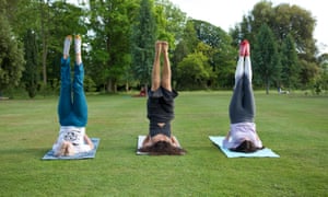 Three guests at Beeja Meditation Retreat, Sussex, try yoga in the grounds.