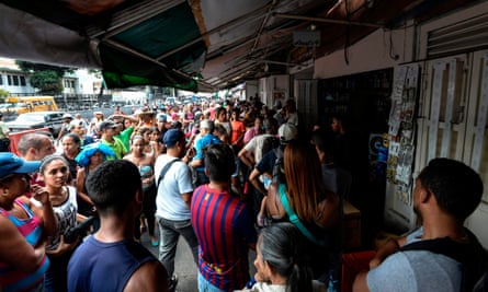 People queue to buy food at Petare neighborhood in Caracas on Sunday during a massive power outage.