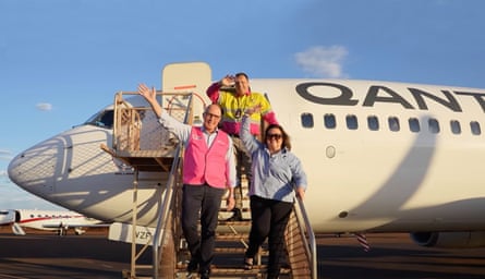 The pair wave as they disembark from a Qantas plane