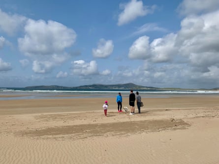 A family stands on a deserted beach