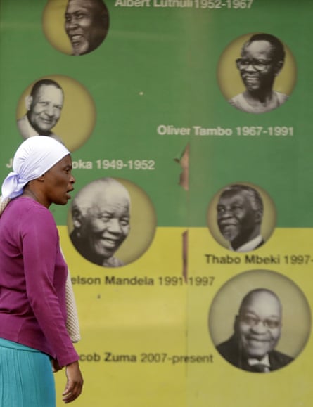Woman walks past poster with faces of previous ANC leaders