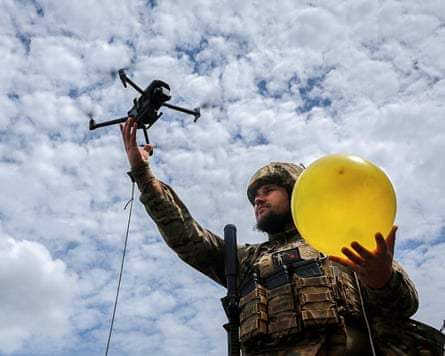 A Ukrainian serviceman lifts a drone attached to a balloon for target practice during anti-drone training at an undisclosed location near the frontline in the Kharkiv region