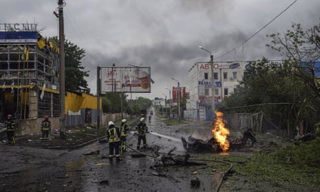 Rescue workers put out the fire of a destroyed car after a Russian attack in a residential neighborhood in downtown Kharkiv, Ukraine, on Monday, July 11.