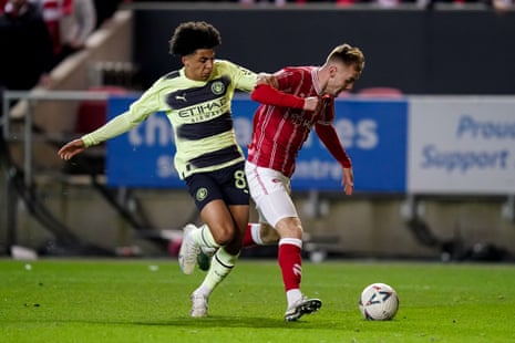 Mark Sykes of Bristol City is challenged by Rico Lewis of Manchester City.
