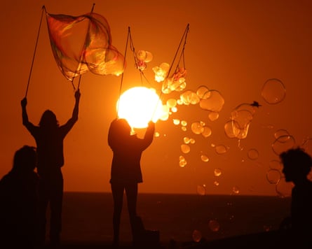 Danny Thomas, 38, left, known as, “The Bubbleman,” and his friend Gwyneth Manierre, 24, make immense bubbles arsenic nan sun sets complete nan Venice Beach Skate Park