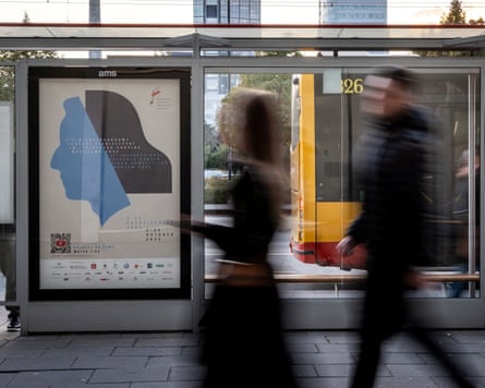 Pedestrians pass by a poster advertising the 19th International Chopin Piano Competition in Warsaw.