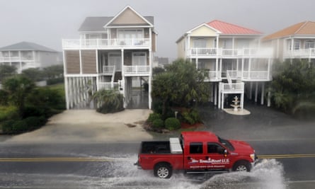 A vehicle drives through floodwaters in Ocean Isle Beach, north Carolina, on Sunday. 