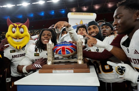 Players from Arizona State and their mascot Sparky celebrate on the pitch with the trophy