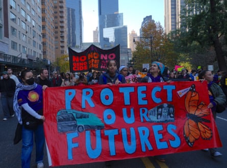 People march holding banner saying Protect Our Futures.