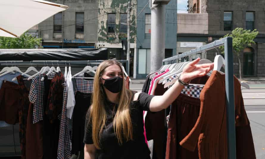 Juliet Sulejmani, store manager astatine Alpha 60’s Fitzroy store, adjusts the outdoor covering racks
