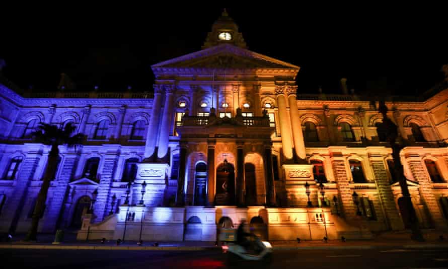 A motorcyclist rides past Cape Town's City Hall, lit up in the colors of the Ukrainian flag, on March 2.