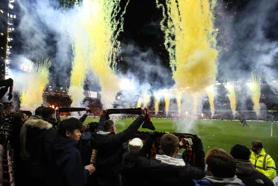 Fans hold scarves aloft in memory of former manager Graham Taylor as fireworks go off at Vicarage Road ahead of the match against Norwich.