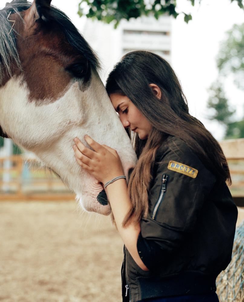 ‘I come here to be with friends. It’s become a huge part of my life – it’s just a big family here’: Maria with one of the horses she helps look after.