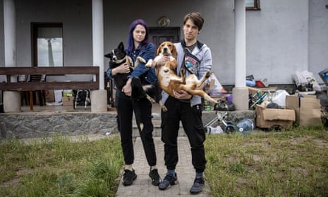 Anastasiya Tikha, 20, and her huband Arthur Lee, 26, with two of their dogs outside their home in Irpin. 