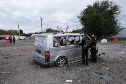 Ukrainian police examine a minivan that was hit in a Russian strike on a convoy heading for Kremlin occupied territory.