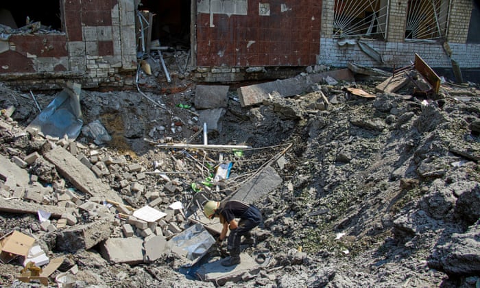 Ukrainian rescuers clean debris at a school hit by shelling in Kharkiv, Ukraine.