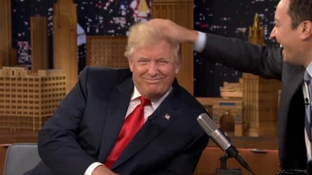 a man rubs the top of another man's head while laughing