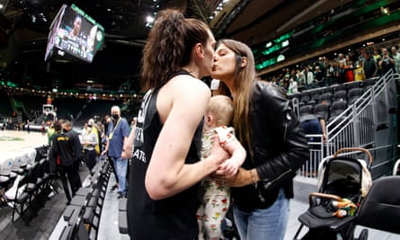 Breanna Stewart kisses her wife Marta Xargay Casademont while holding their daughter Ruby Mae Stewart Xargay after a 2022 game.