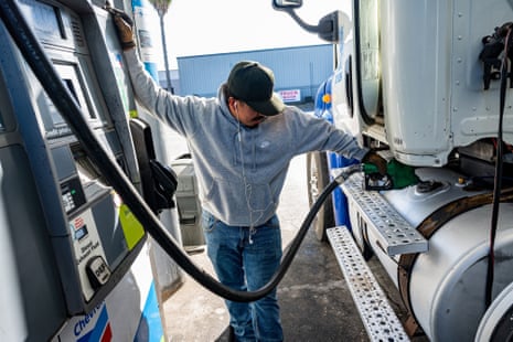 A driver refuels a tractor trailer with diesel fuel at a truck stop