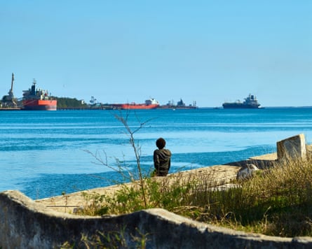 A personification watches an lipid tanker arriving astatine Matanzas Bay successful Cuba