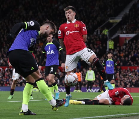 Lisandro Martinez of Manchester United in action with Rodrigo Bentancur of Tottenham Hotspur whilst Manchester United’s Diogo Dalot lies injured.