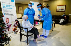 An employee of the El Viso nursing home speaks with Amalia Gonzalez, 96, before her injection with a dose of the Pfizer-BioNTech vaccine in Madrid, Spain on 7 January, 2021.