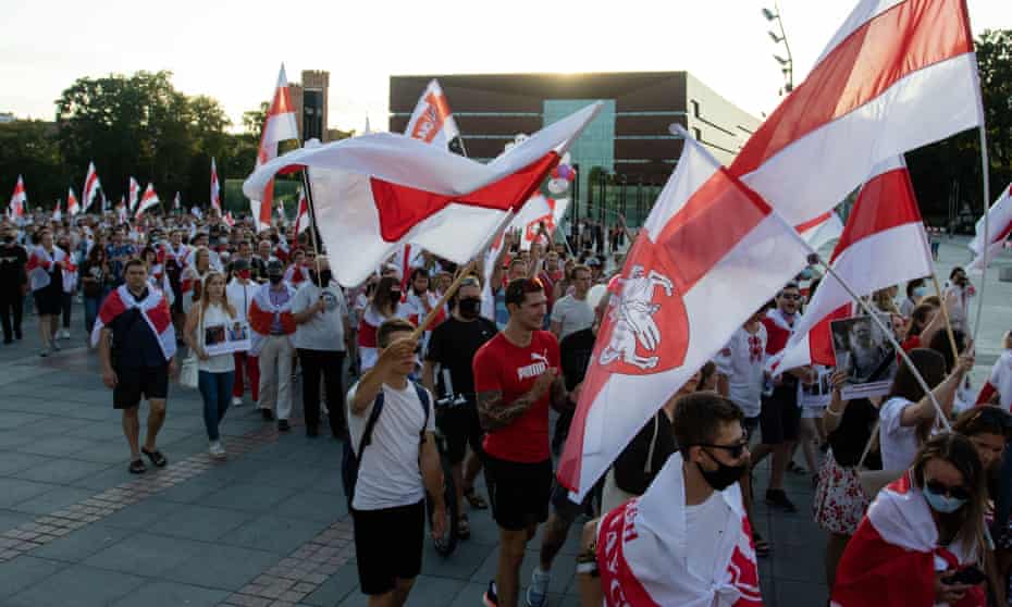 Demonstrators march with Belarusian opposition flags at a solidarity rally with Belarus in Wroclaw, Poland