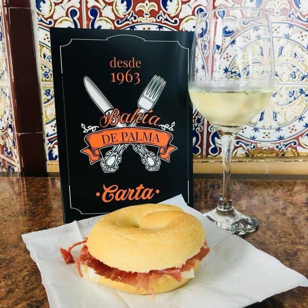 Bagel and a glass of wine in front of the menu at Bahia De Palma, Almeria, Spain.