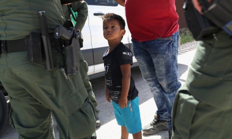 A boy and father from Honduras are taken into custody by US Border Patrol agents near Mission, Texas.