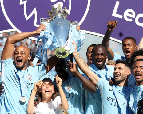 Vincent Kompany (left), Yaya Touré (second right) and Sergio Agüero lift the Premier League trophy in 2018.