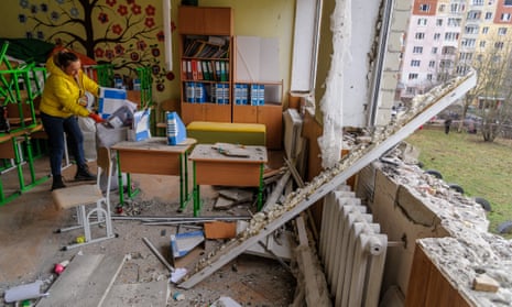 A woman cleans a classroom with broken windows after a Russian missile attack in Lviv on Friday morning.