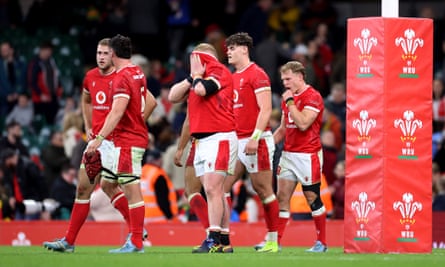 Keiron Assiratti of Wales looks dejected with teammates after defeat to Australia.