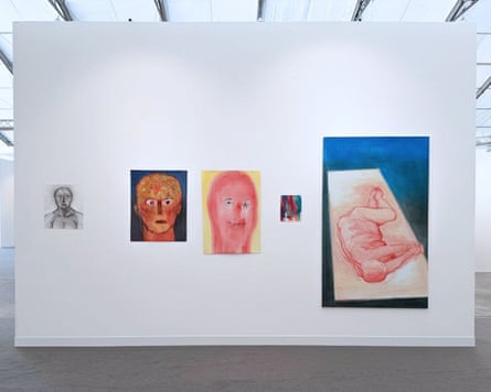 Five varying portraits are hung on a white wall