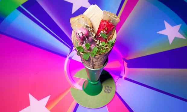 A cone containing bright coloured jellied sticks in the centre of a multi-coloured 'pie chart' background