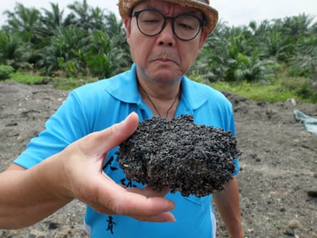 C.K. Lee, a lawyer and activist, with burned plastic residue in Kuala Langat.
