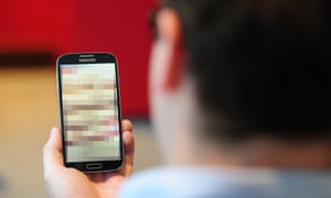 A man looking at a pixellated photo on his phone