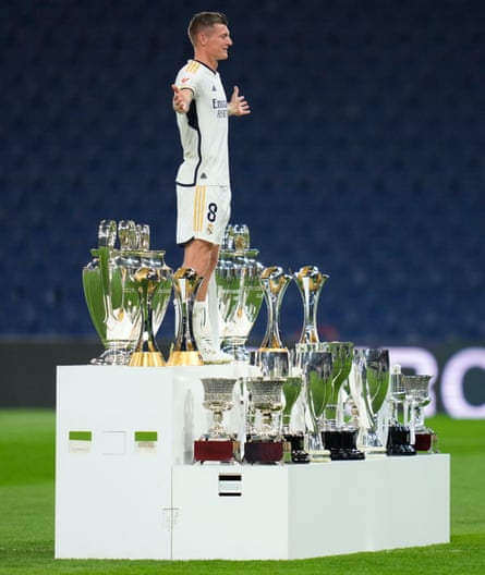 Toni Kroos poses with trophies he won with Madrid.