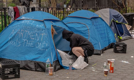 People in and around tents as NYPD conduct a sweep of a homeless encampment adjacent to Tompkins Square Park in New York City.