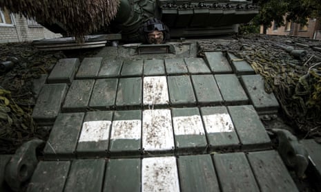 A Ukrainian serviceman sits in a tank in the recently recaptured city of Izium, eastern Ukraine