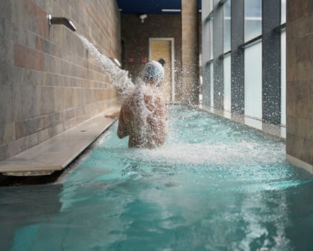General side view of people under a waterfall jet in health spa. Concept of spa.