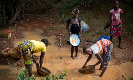 Women pan for gold in the mining area of Siguiri, Guinea