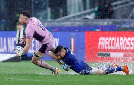Italy’s Alessandro Fusco tries to curtail Jack Dempsey’s progress as the standing water mounts at Stadio Olimpico