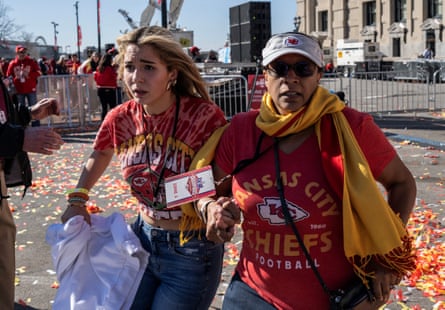 two women in kansas city chiefs t shirts running away
