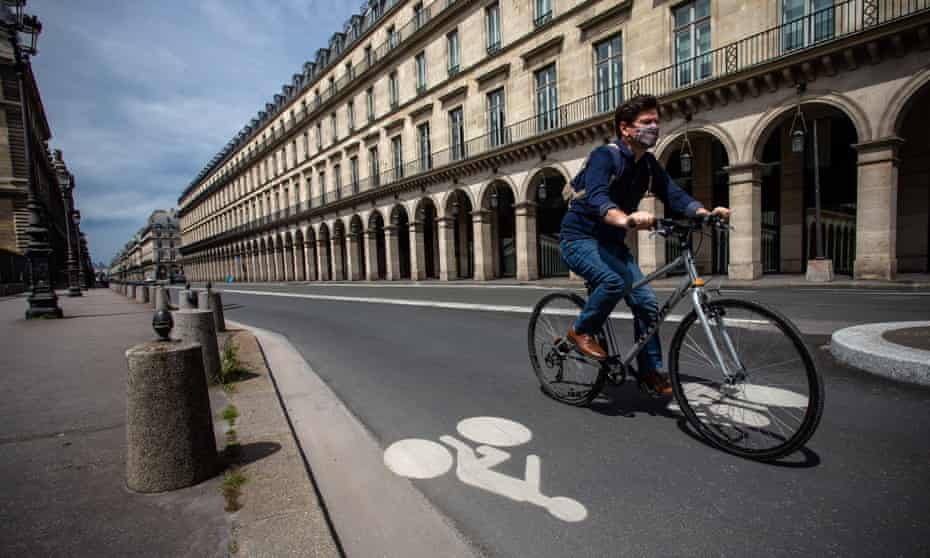 A man rides a bicycle on Paris’s Rue de Rivoli, where cars have been banned. Cycling is being encouraged in Paris to reduce overcrowding on trains and buses, and the city has opened temporary bike lanes.